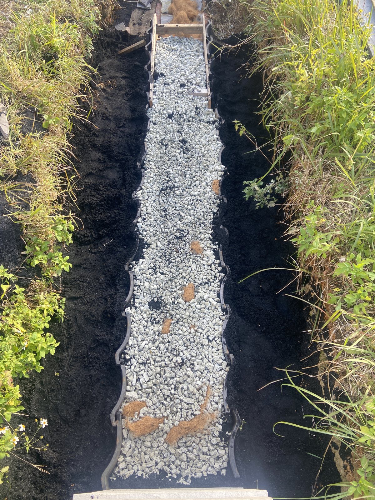 割石の上に砕石を入れた状態。外側には黒い炭の層が見える