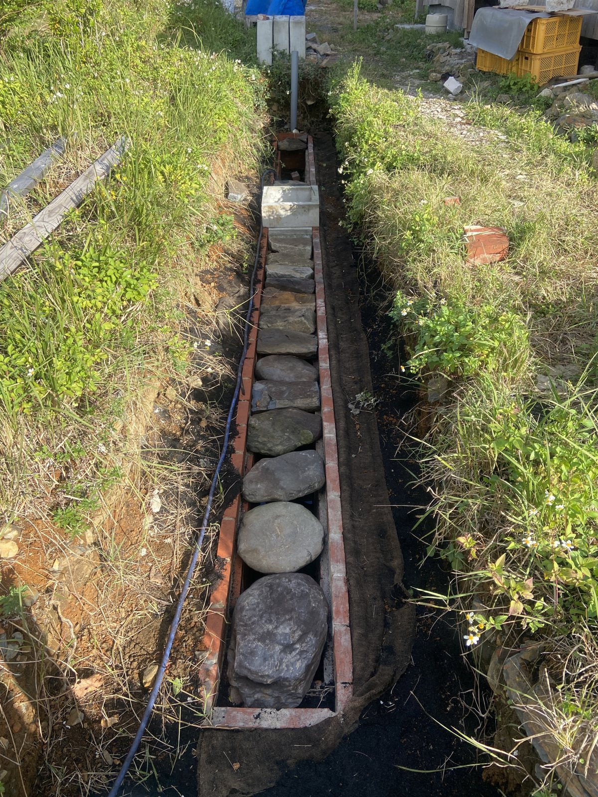 槽の中に川の丸石を並べた状態。石の隙間を水と空気が通る